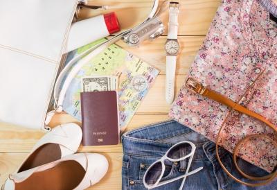photo of a purse, sunglasses, flats, passport and cash