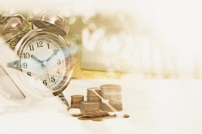 alarm clock on table with coins