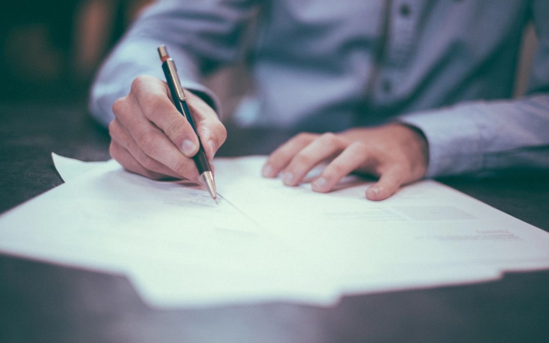 man signing documents