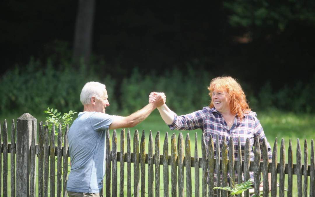 two people shaking hands across a fence