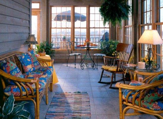 photo of a sunroom porch with bench couch, rocking chair and side chair