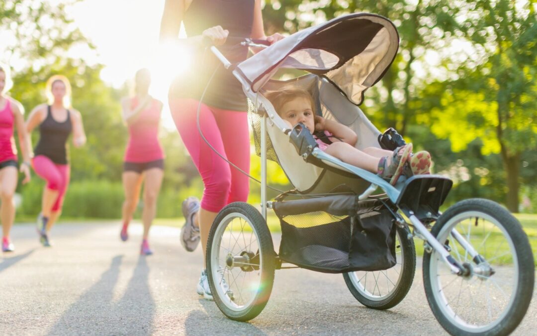 A woman who is running with a group of other women is pushing a running stroller with a new baby. Life changes! Don't forget to update your estate plan with every major change, such as a new baby.